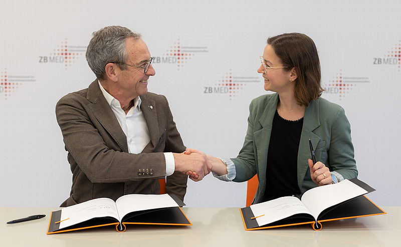 Handshake zwischen Peter Roth, MDPI Head of Publishing, und Franziska Fischer, Kaufmännische Geschäftsführerin ZB MED